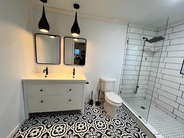 bathroom featuring a tile shower, vanity, crown molding, and toilet