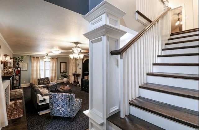 stairs with a textured ceiling, ceiling fan, and crown molding