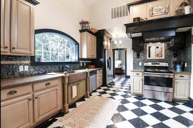 kitchen featuring vaulted ceiling, backsplash, sink, and stainless steel appliances