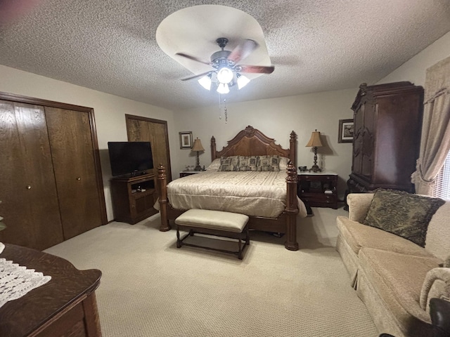 bedroom featuring ceiling fan, light carpet, and a textured ceiling