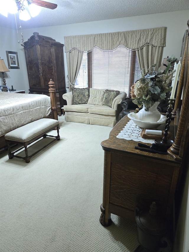 carpeted bedroom featuring ceiling fan and a textured ceiling