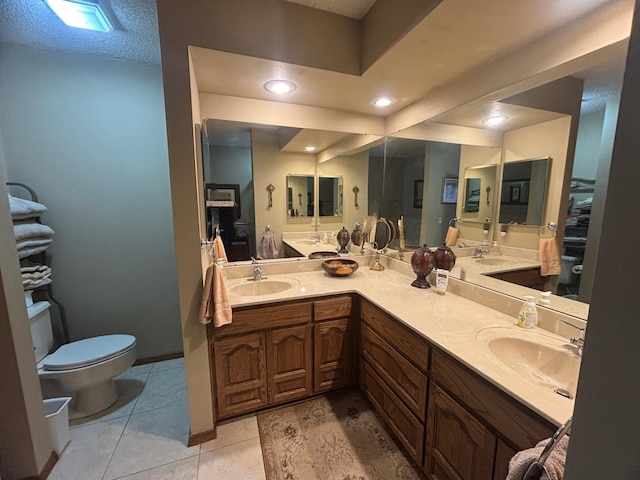 bathroom featuring a textured ceiling, tile patterned floors, vanity, and toilet