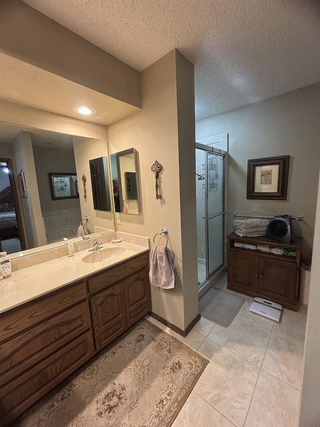 bathroom with a shower with shower door, vanity, tile patterned floors, and a textured ceiling