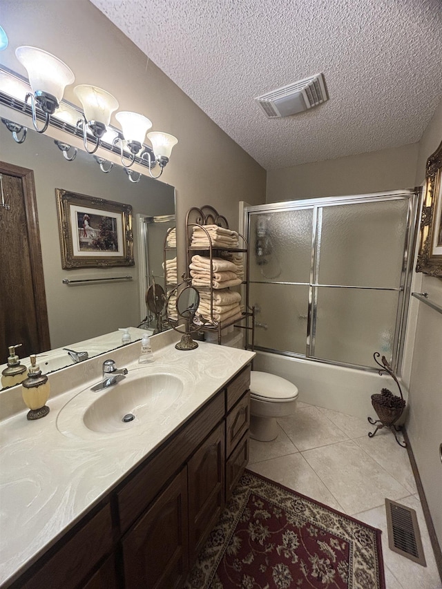 full bathroom featuring toilet, tile patterned flooring, a textured ceiling, vanity, and shower / bath combination with glass door