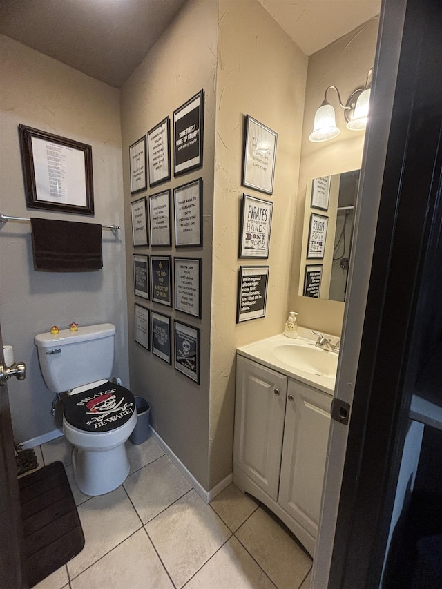 bathroom with toilet, vanity, and tile patterned flooring