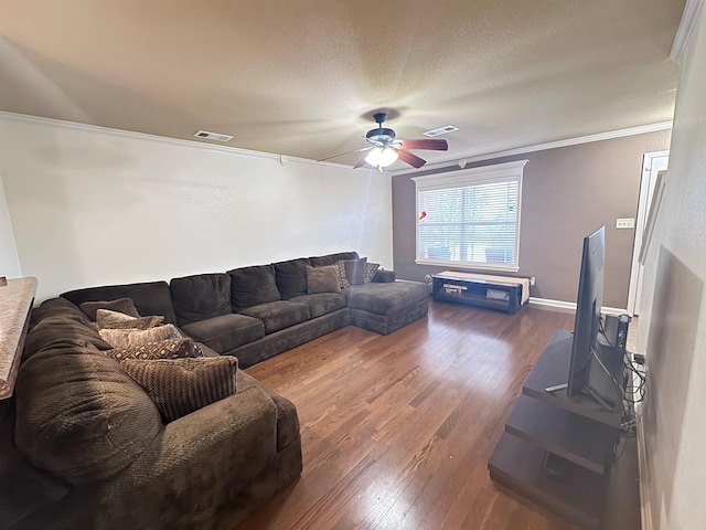 living room featuring dark wood-type flooring, ceiling fan, crown molding, and a textured ceiling