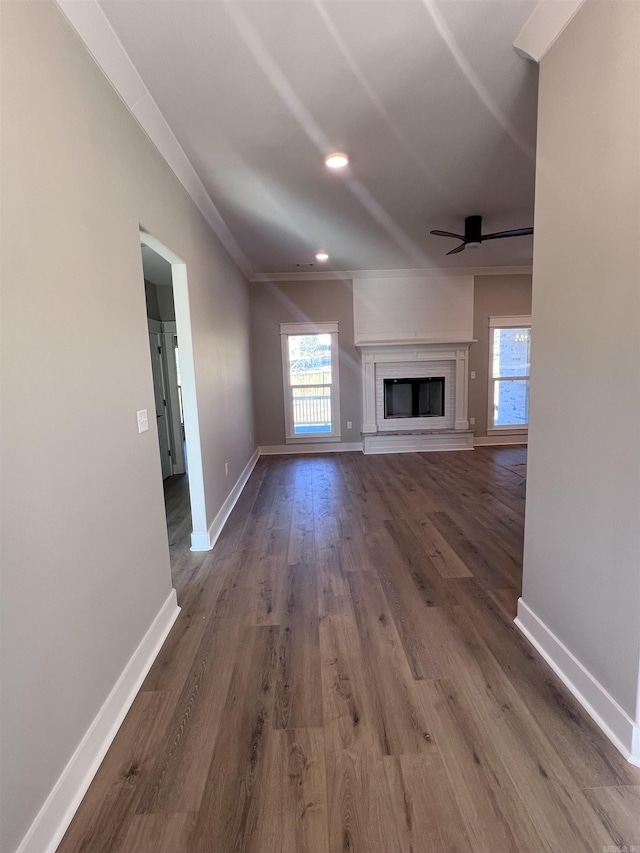 unfurnished living room with ceiling fan, wood-type flooring, and ornamental molding