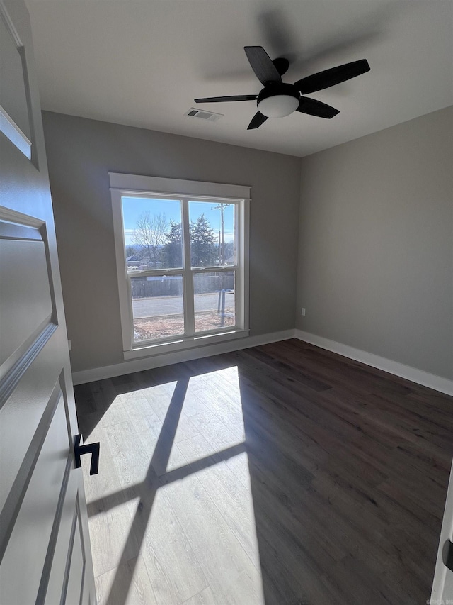 empty room with ceiling fan and dark hardwood / wood-style floors