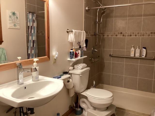 bathroom featuring toilet, sink, and curtained shower