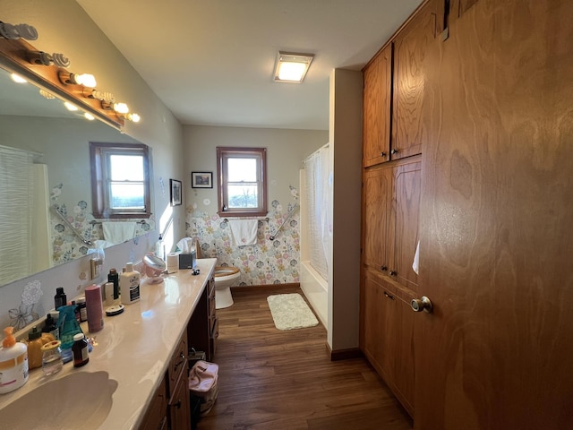 full bathroom with hardwood / wood-style floors, toilet, vanity, and shower / tub combo