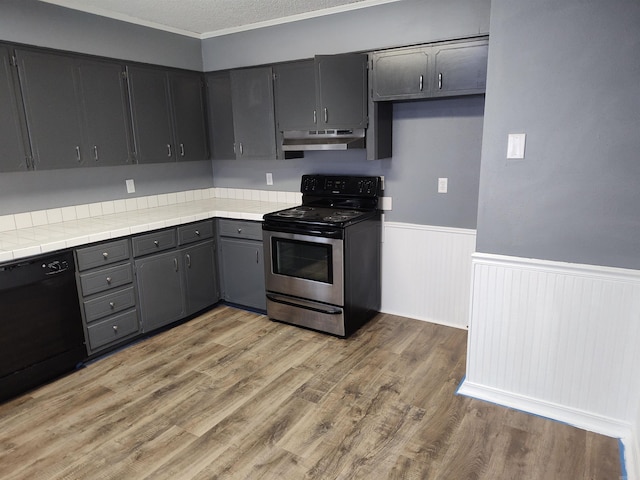 kitchen with stainless steel electric stove, wood-type flooring, dishwasher, and tile counters