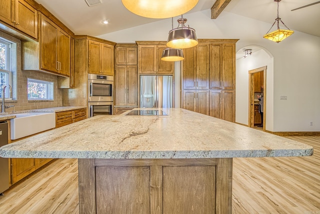 kitchen with decorative light fixtures, a spacious island, stainless steel appliances, and lofted ceiling with beams