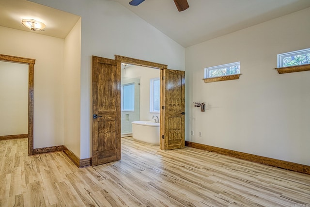 interior space featuring ceiling fan, ensuite bathroom, light hardwood / wood-style flooring, and lofted ceiling