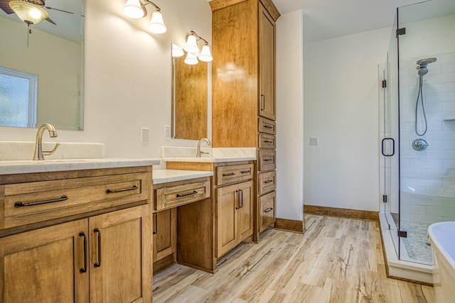 bathroom featuring separate shower and tub, vanity, wood-type flooring, and ceiling fan