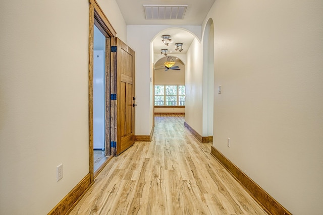 hallway with light hardwood / wood-style floors