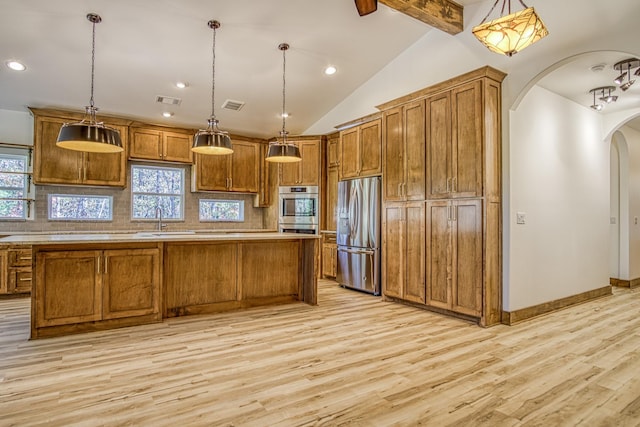 kitchen featuring appliances with stainless steel finishes, light hardwood / wood-style floors, a center island, and decorative light fixtures