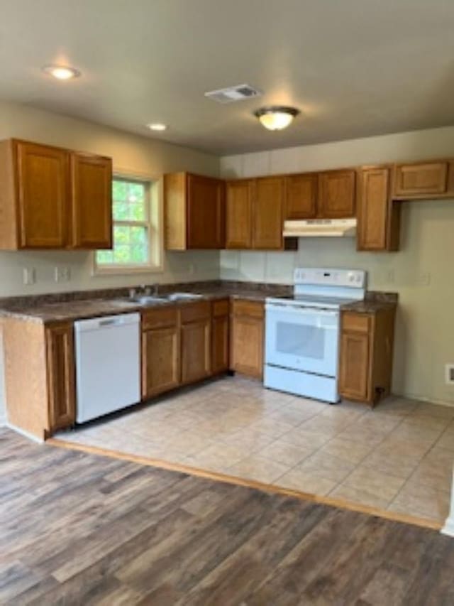 kitchen featuring light wood-type flooring, sink, and white appliances