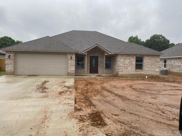 view of front of property with a garage and central AC