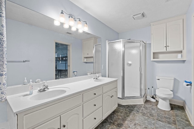 bathroom featuring a textured ceiling, an enclosed shower, vanity, and toilet