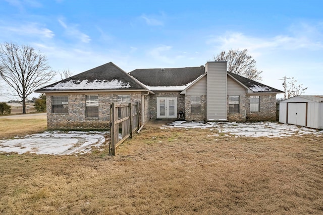 back of house with a storage shed, french doors, and a yard