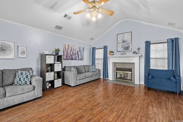 living room with hardwood / wood-style flooring, ornamental molding, lofted ceiling, and a fireplace