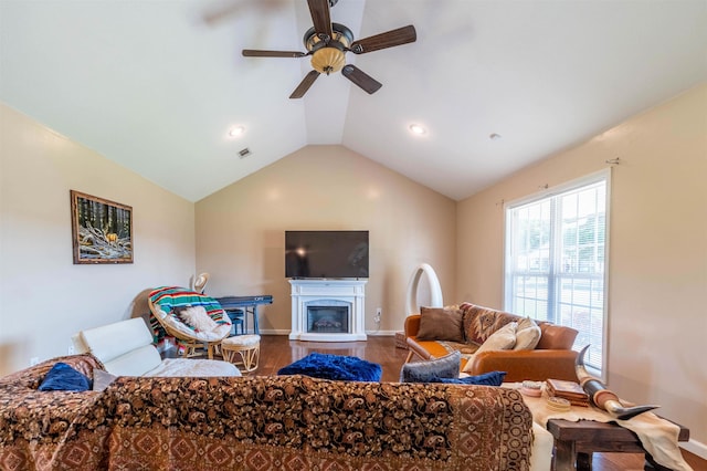 living room featuring hardwood / wood-style flooring, ceiling fan, and vaulted ceiling