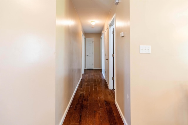 corridor with dark hardwood / wood-style flooring