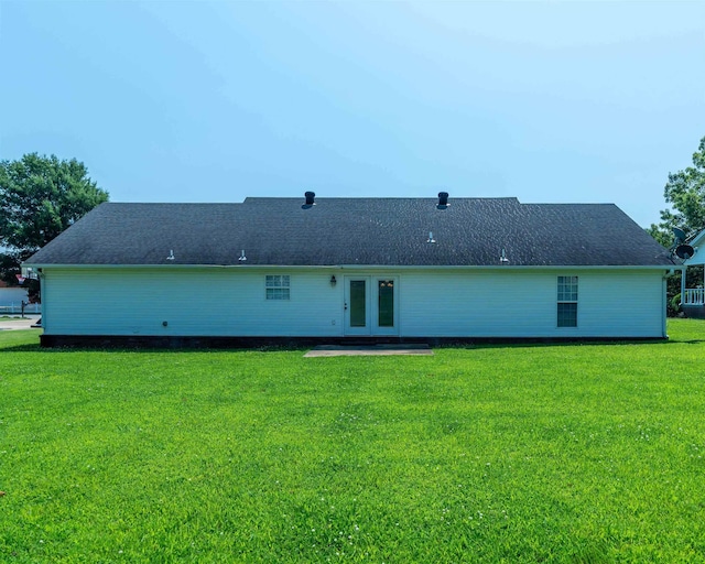 rear view of house with french doors and a yard