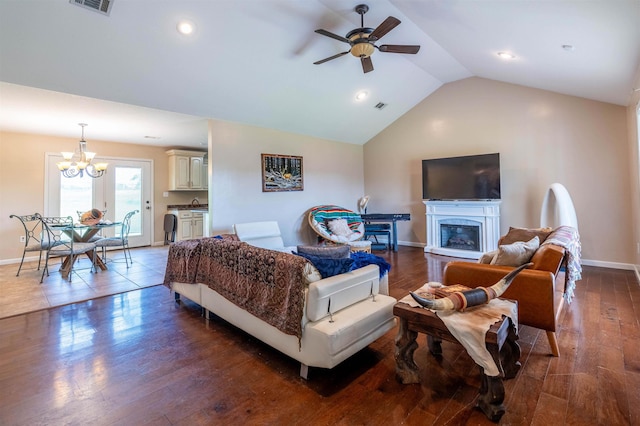 living room with vaulted ceiling, dark hardwood / wood-style flooring, and ceiling fan with notable chandelier