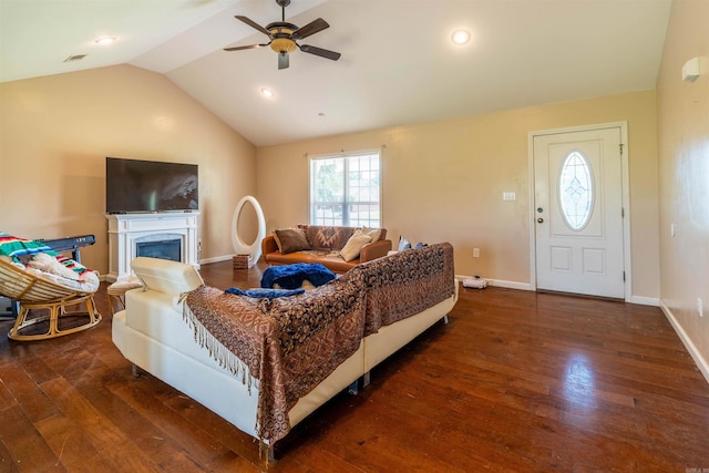 living room with ceiling fan, dark wood-type flooring, and vaulted ceiling