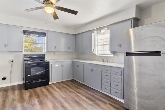 kitchen with sink, black / electric stove, gray cabinetry, and stainless steel refrigerator