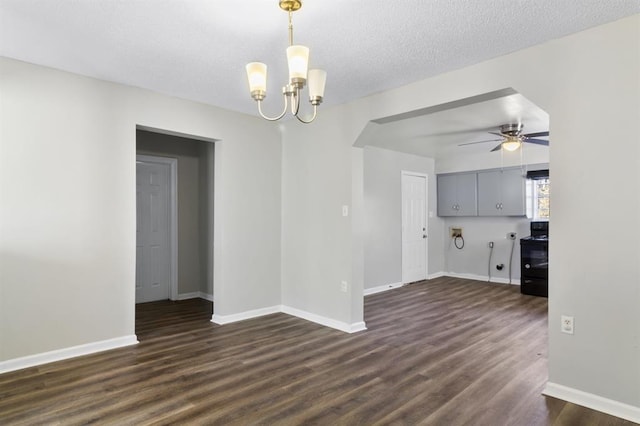 empty room featuring a textured ceiling, dark wood-type flooring, and ceiling fan with notable chandelier