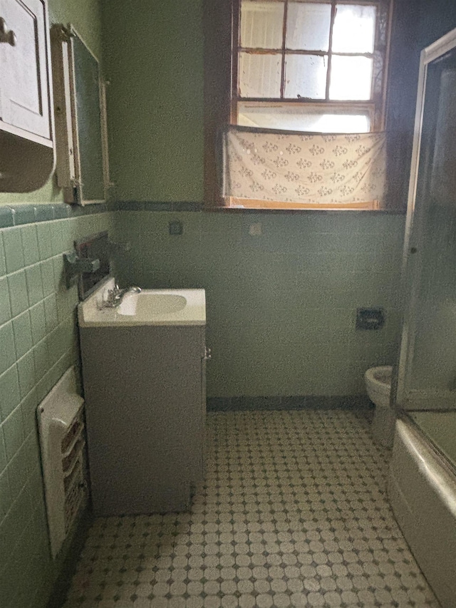 bathroom with toilet, tile walls, and vanity