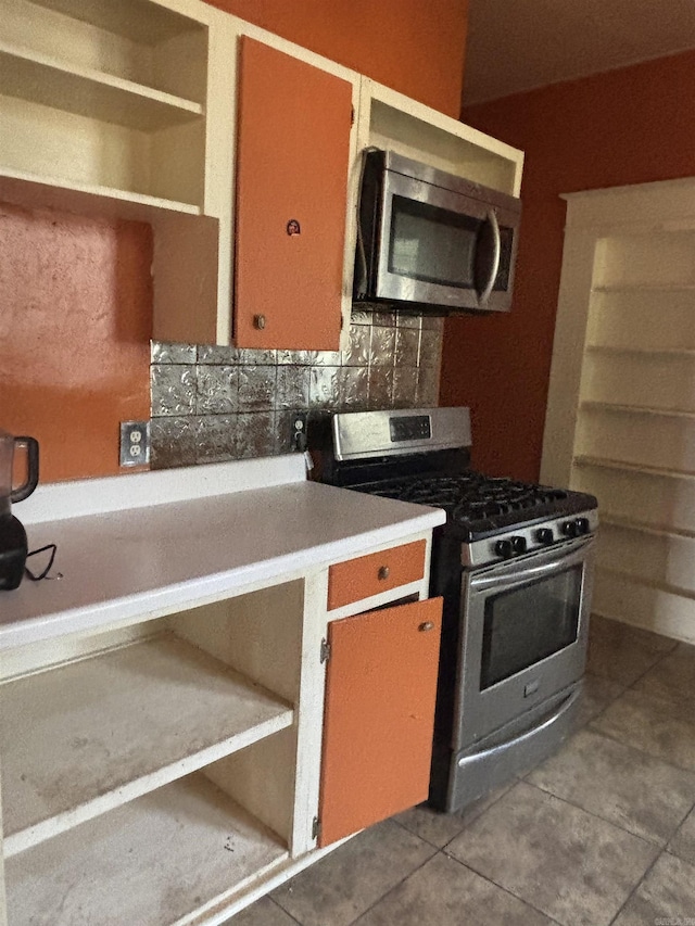 kitchen with light tile patterned floors, decorative backsplash, and appliances with stainless steel finishes