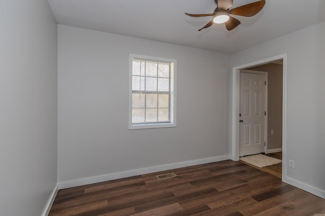 spare room featuring ceiling fan and dark wood-type flooring