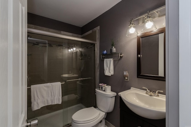 bathroom with a shower with shower door, toilet, and vanity