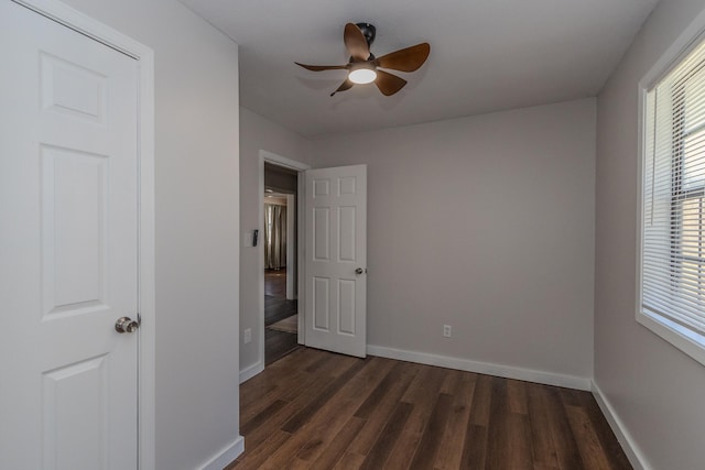 unfurnished bedroom with ceiling fan and dark hardwood / wood-style flooring