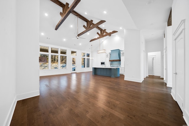 unfurnished living room featuring dark hardwood / wood-style floors, ceiling fan, beam ceiling, and high vaulted ceiling