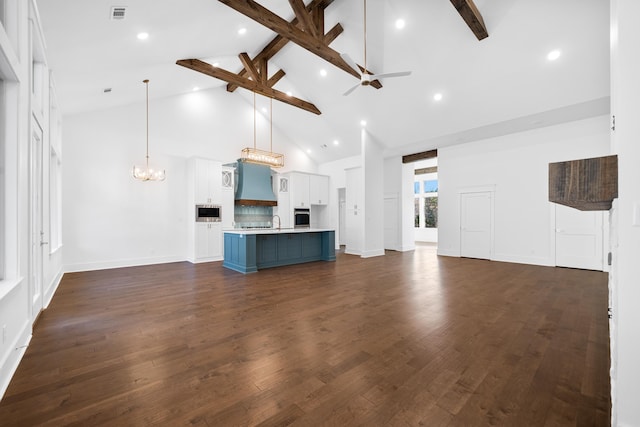 unfurnished living room with dark hardwood / wood-style flooring, beam ceiling, ceiling fan with notable chandelier, and high vaulted ceiling