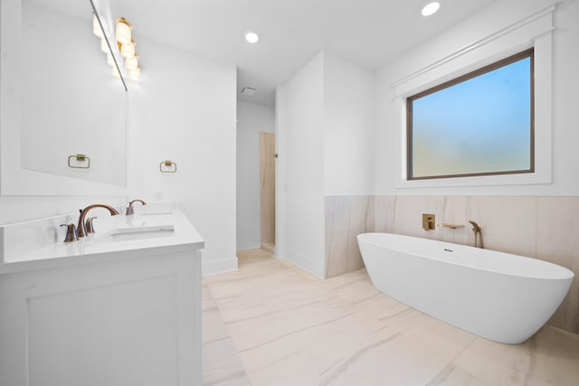 bathroom with vanity and a tub