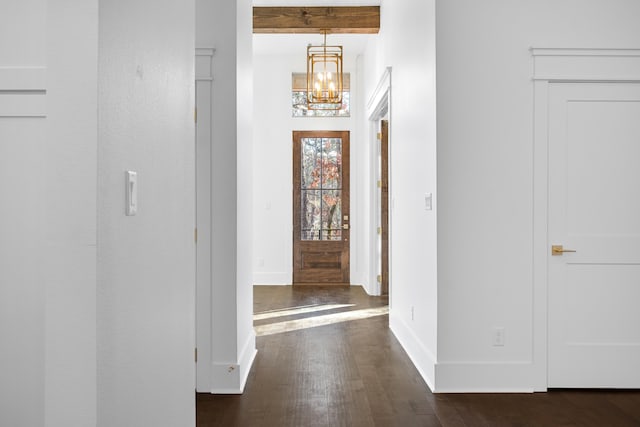 corridor featuring beamed ceiling, dark hardwood / wood-style floors, and a chandelier