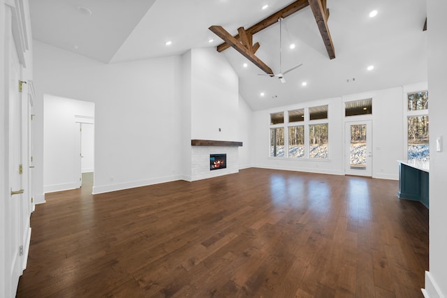 unfurnished living room featuring ceiling fan, high vaulted ceiling, dark hardwood / wood-style floors, and beamed ceiling