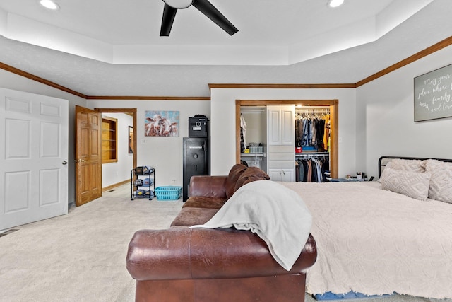 bedroom featuring ceiling fan, a closet, light carpet, and a raised ceiling