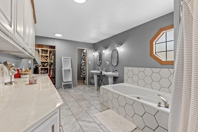 bathroom featuring a relaxing tiled tub and sink