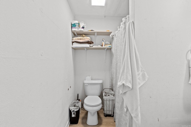 bathroom with toilet and hardwood / wood-style flooring