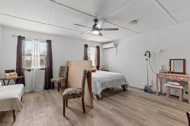 bedroom with light wood-type flooring, ceiling fan, a paneled ceiling, and a wall mounted air conditioner