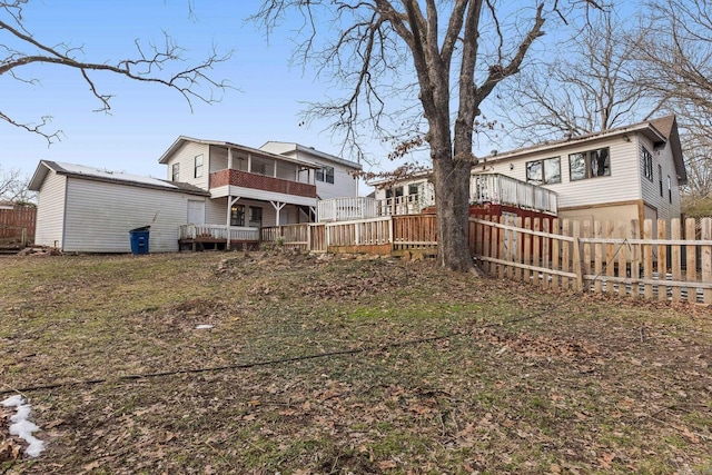 back of house with a lawn and a deck