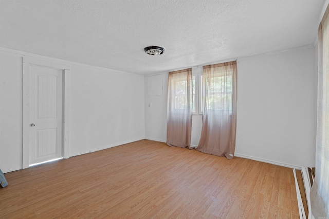 unfurnished room with a textured ceiling and light hardwood / wood-style flooring