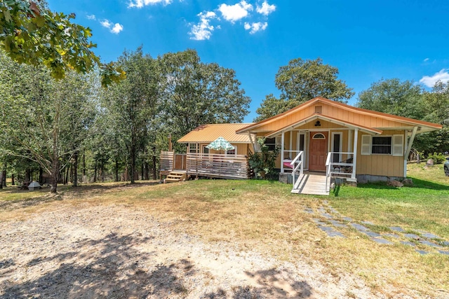 view of front of property featuring a front lawn and a wooden deck