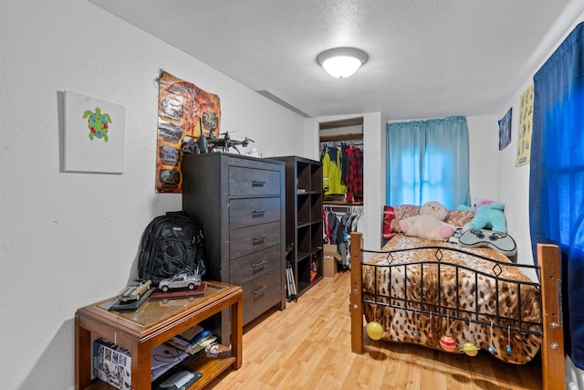 bedroom featuring a textured ceiling, a closet, and wood-type flooring